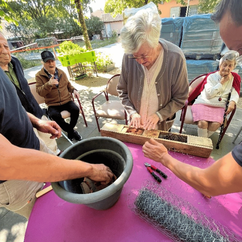 Fabrication d'un hôtel à insectes par les résidents de Saint-Quentin-La-Poterie : Les Jardins